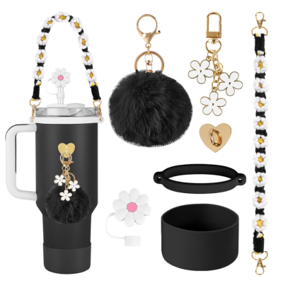 Conjunto de garrafa térmica preta e acessórios decorativos com temas de flores brancas e amarelas