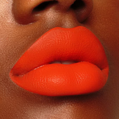 Lábios com batom laranja mate em pele castanha escura