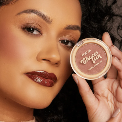Mulher segura blush compacto Fenzza Choco Fun em embalagem redonda