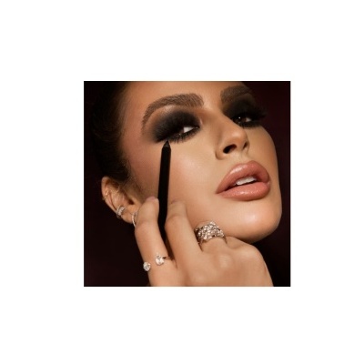 Mulher a aplicar lápis de olhos preto com maquilhagem escura e anéis prateados