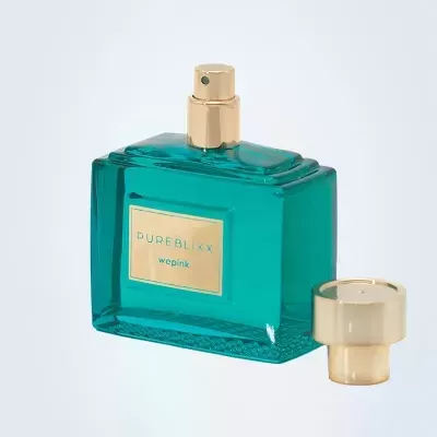 Frasco de perfume verde-azulado com tampa dourada ao lado