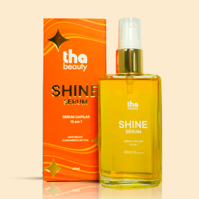 Frasco de sérum capilar amarelo com tampa branca e dourada ao lado da caixa laranja com texto branco e dourado.