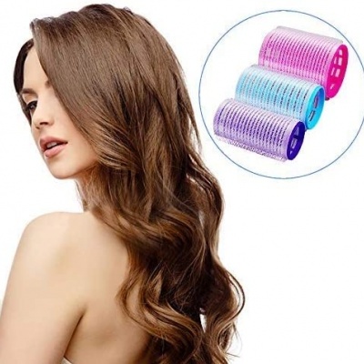 Mulher com cabelo castanho ondulado e três rolos de cabelo coloridos