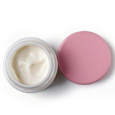Frasco aberto com creme branco e tampa rosa ao lado