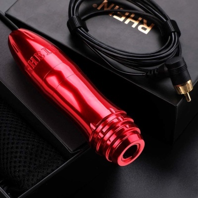 Objeto metálico vermelho brilhante com cabo preto sobre caixa preta