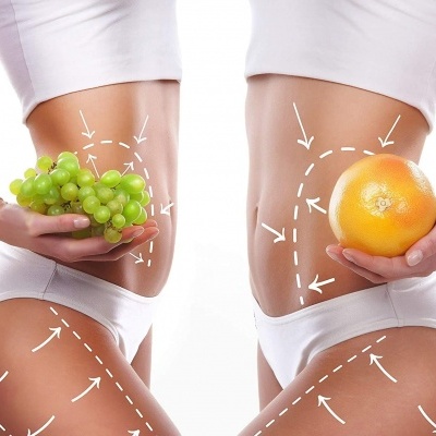 Mulheres em roupa interior branca seguram uvas verdes e toranja com linhas brancas desenhadas no corpo