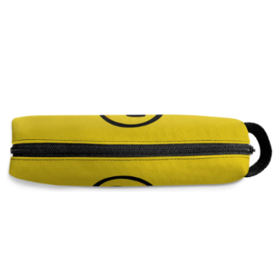 Estojo escolar amarelo com fecho preto e padrão circular negro