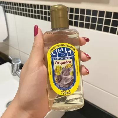 Frasco de limpador perfumado de ambientes COALA Orquídea com rótulo amarelo e azul e imagem de coalas