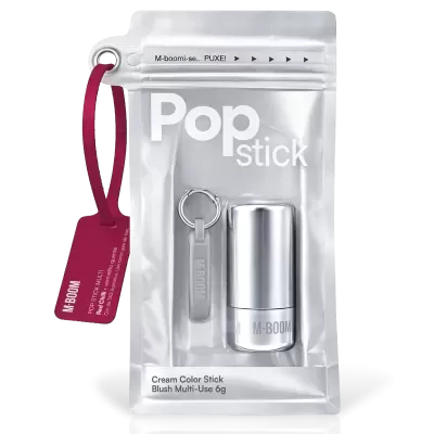 Blush multiusos em stick M-BOOM em embalagem prateada com etiqueta vermelha