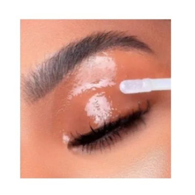 Olho fechado com sobrancelha e aplicação de produto transparente na pálpebra com pincel