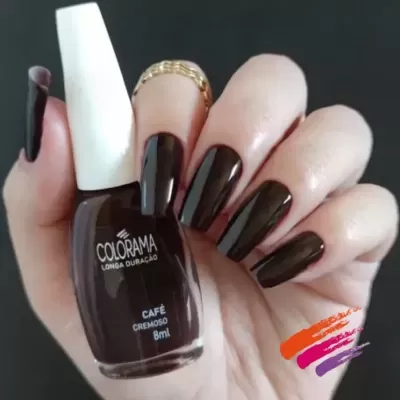 Mão com unhas pintadas de verniz castanho escuro e frasco de verniz Colorama Café Cremoso