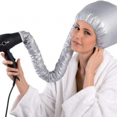 Capacete de secador de cabelo cinza prateado ligado a secador preto, usado por mulher com roupão branco