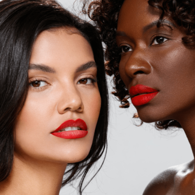 Duas mulheres com batom vermelho vibrante e diferentes tons de pele.