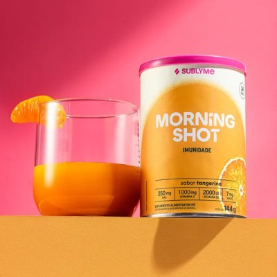 Embalagem Morning Shot sabor tangerina ao lado de copo com bebida laranja e fatia de tangerina