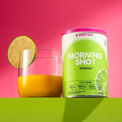 Embalagem cilíndrica de suplemento Morning Shot limão e copo com bebida amarela e limão