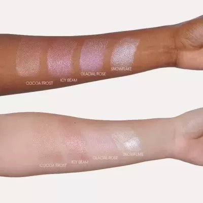 Braços com amostras brilhantes de maquilhagem em cores suaves e nomeadas.