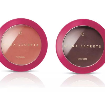 Duas embalagens redondas rosas com pós compactos castanhos e textos dourados