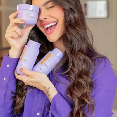 Mulher a segurar embalagens lilás de produtos de cabelo Julienne