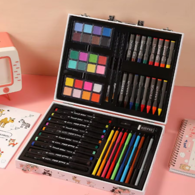 Estojo de material de desenho infantil com várias canetas, lápis e tintas coloridas sobre superfície rosa