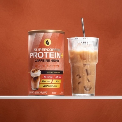Lata de Supercoffee Protein+ ao lado de copo com bebida gelada