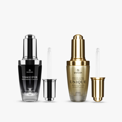 Dois frascos de sérum com conta-gotas, um preto prateado e um dourado, marca SAVIORA