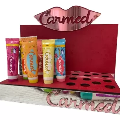 Expositor vermelho e espelhado com tubos coloridos de creme dental Carmed