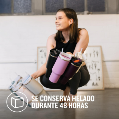 Mulher segura vários copos térmicos coloridos com tampa e canudo em interior branco