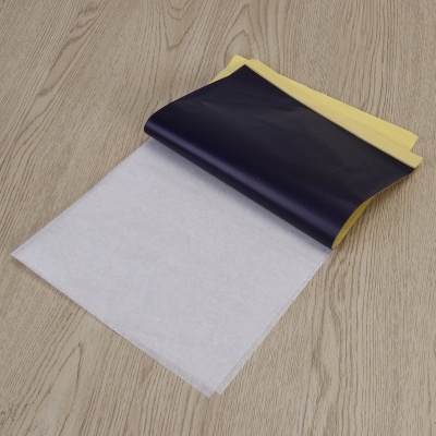 Folha adesiva preta e amarela sobre superfície de madeira clara