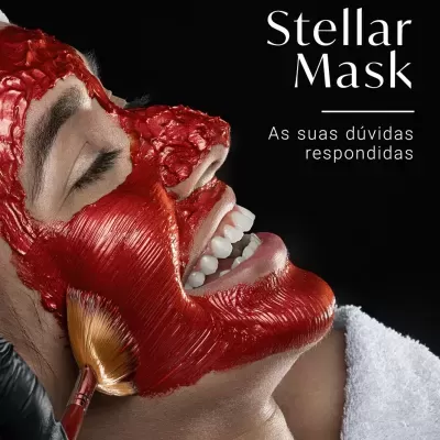 Pessoa a receber máscara facial vermelha aplicada com pincel sobre fundo preto