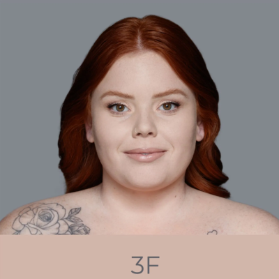 Mulher ruiva com tatuagem de rosa no ombro e texto 3F