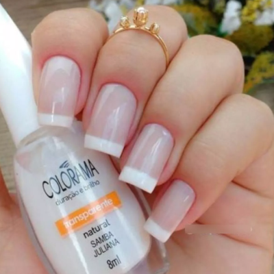 Mão com unhas feitas segurando frasco de verniz Colorama transparente