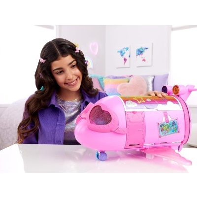 Brinquedo avião cor-de-rosa com menina ao fundo