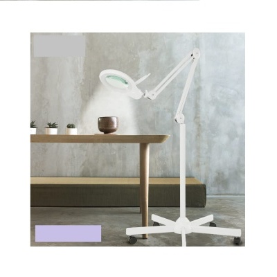 Lâmpada de exame branca com braço articulado ao lado de mesa de madeira