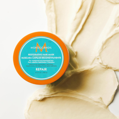 Frasco de máscara capilar Moroccanoil sobre pasta creme clara