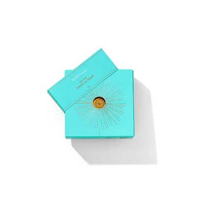 Caixa azul-turquesa de pó iluminador Kjaer Weis com decoração dourada
