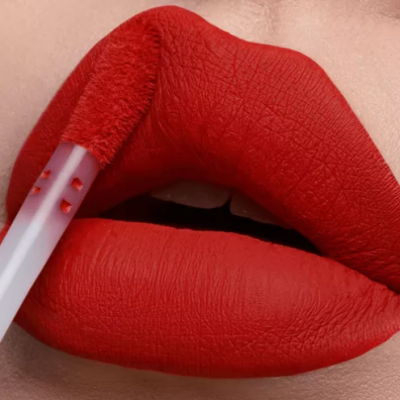 Close-up de lábios a aplicar batom líquido vermelho