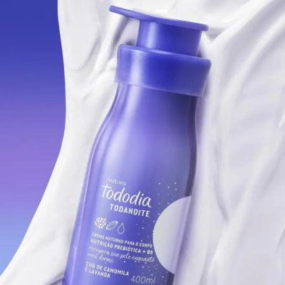 Frasco roxo de creme noturno para o corpo Natura Tododia Todanoite sobre tecido branco