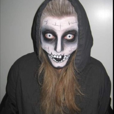 Pessoa com maquiagem de crânio e túnica preta com capuz