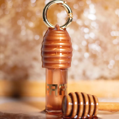 Frasco em acrílico cor de mel com anel dourado e colher mexedora de mel