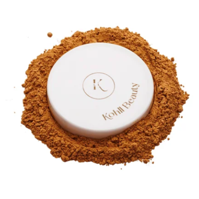 Pó compacto de maquilhagem com embalagem branca e texto Kohll Beauty rodeado por pó castanho
