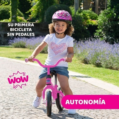 Menina numa bicicleta sem pedais cor-de-rosa com capacete e t-shirt branca, texto promocional em espanhol.