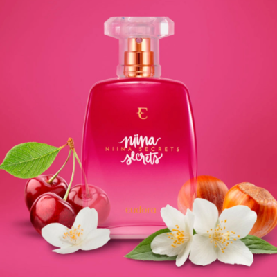 Frasco de perfume rosa com frutas e flores ao redor
