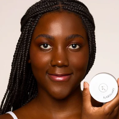 Mulher segurando um frasco redondo branco de produtos de skincare