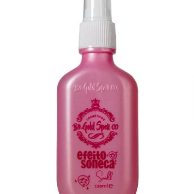 Frasco rosa com spray branco e texto vermelho de produto cosmético