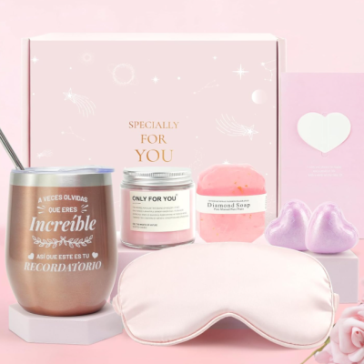 Conjunto de produtos para bem-estar em tons rosa e cinza com chávena metálica, vela, sabão, máscara de dormir e corações brilhantes