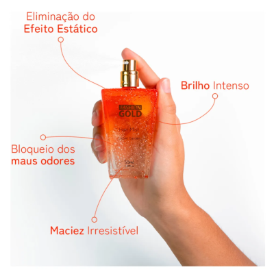 Frasco de spray alaranjado FASHION GOLD Hair Mist segurado numa mão