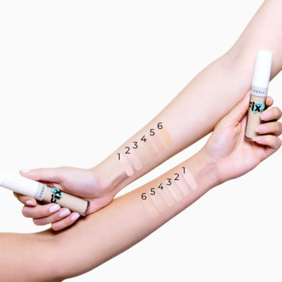 Amostras de base líquida em seis tons numerados em dois braços, embalagem branca com rotulo 'Fix'.