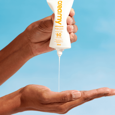 Derramando loção de um tubo branco com texto amarelo e laranja