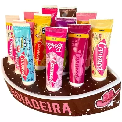 Conjunto de tubos de creme labial Carmed em expositor castanho decorado com estrelas e texto BOLADERA