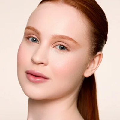 Rosto de mulher com pele clara e cabelo ruivo puxado para trás